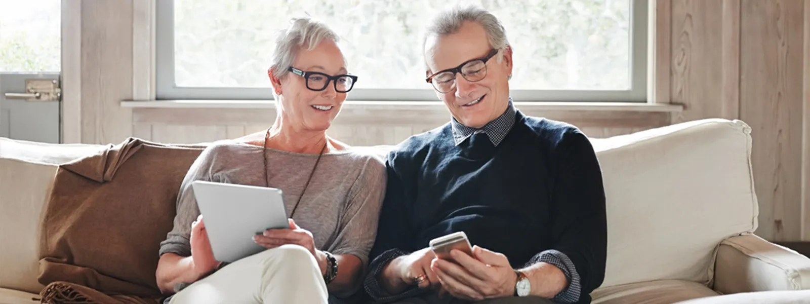 couple sitting on couch with devices