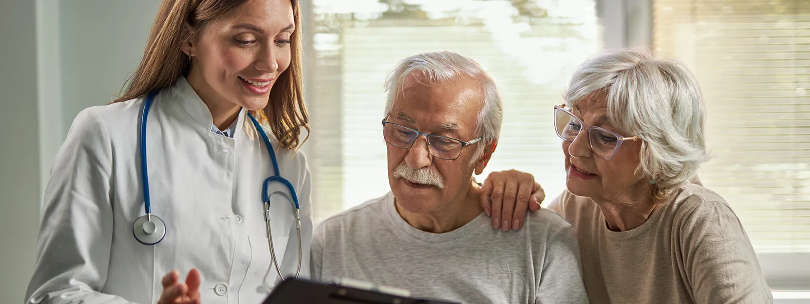 Senior woman and her husband talking with a female doctor during an appointment.